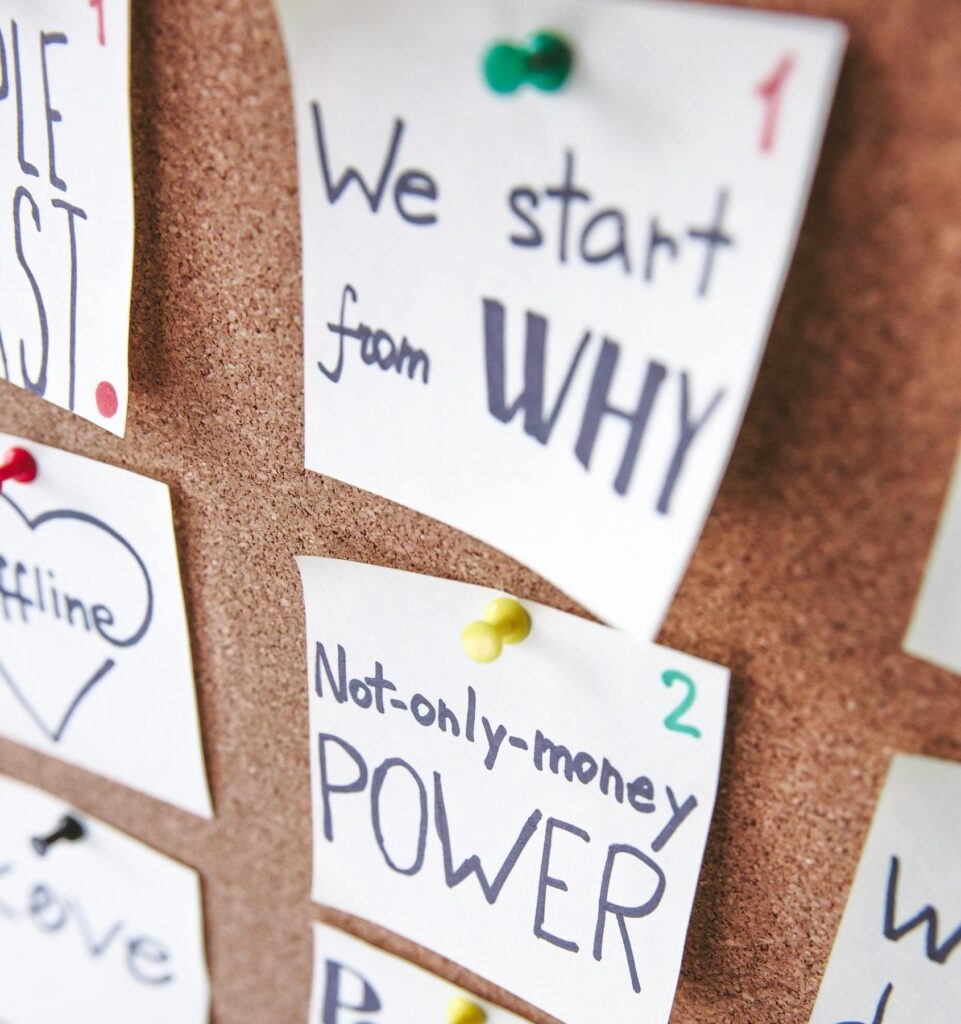 Close-up of motivational sticky notes with messages on a cork board.